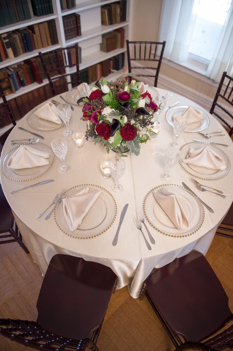Weddings at Tarrywile Clear charger plates with white linen tablecloth, add a bold red centerpiece