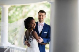A July Tent Wedding natalia and max holding each other close as her veil floats on wind